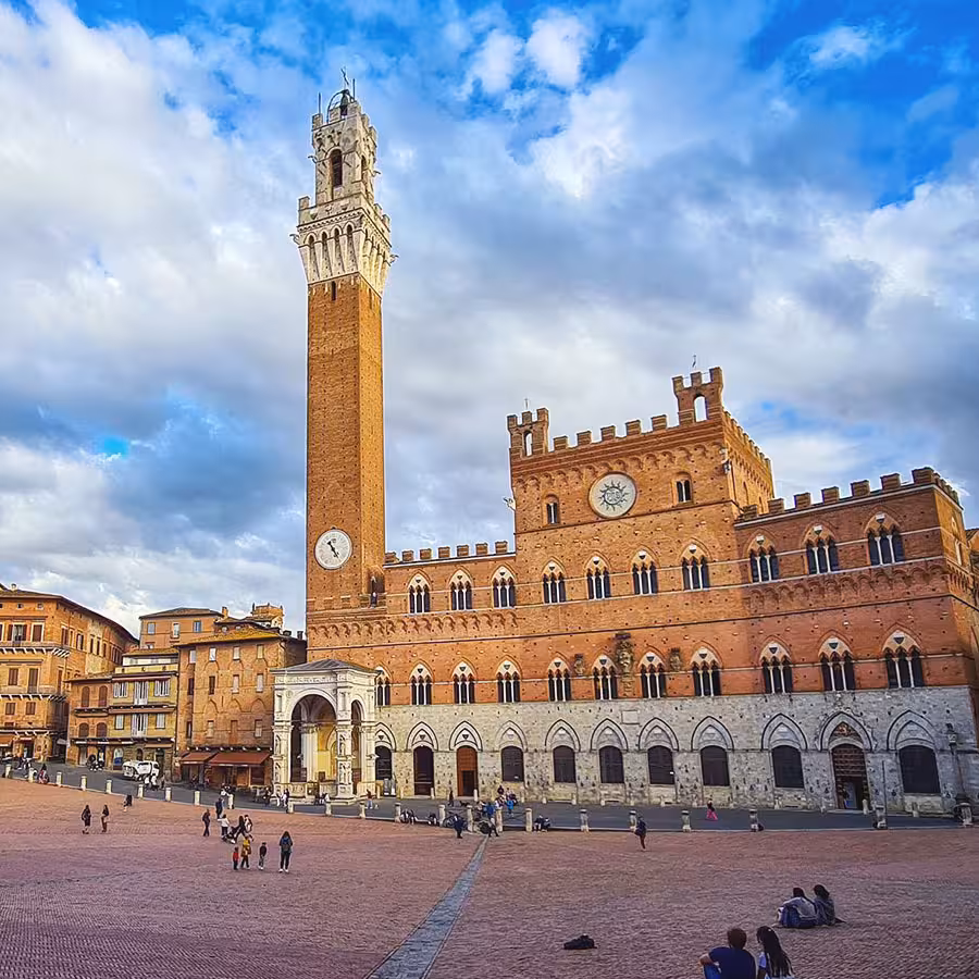 Piazza del Campo a Siena gremita di persone durante una giornata di sole.