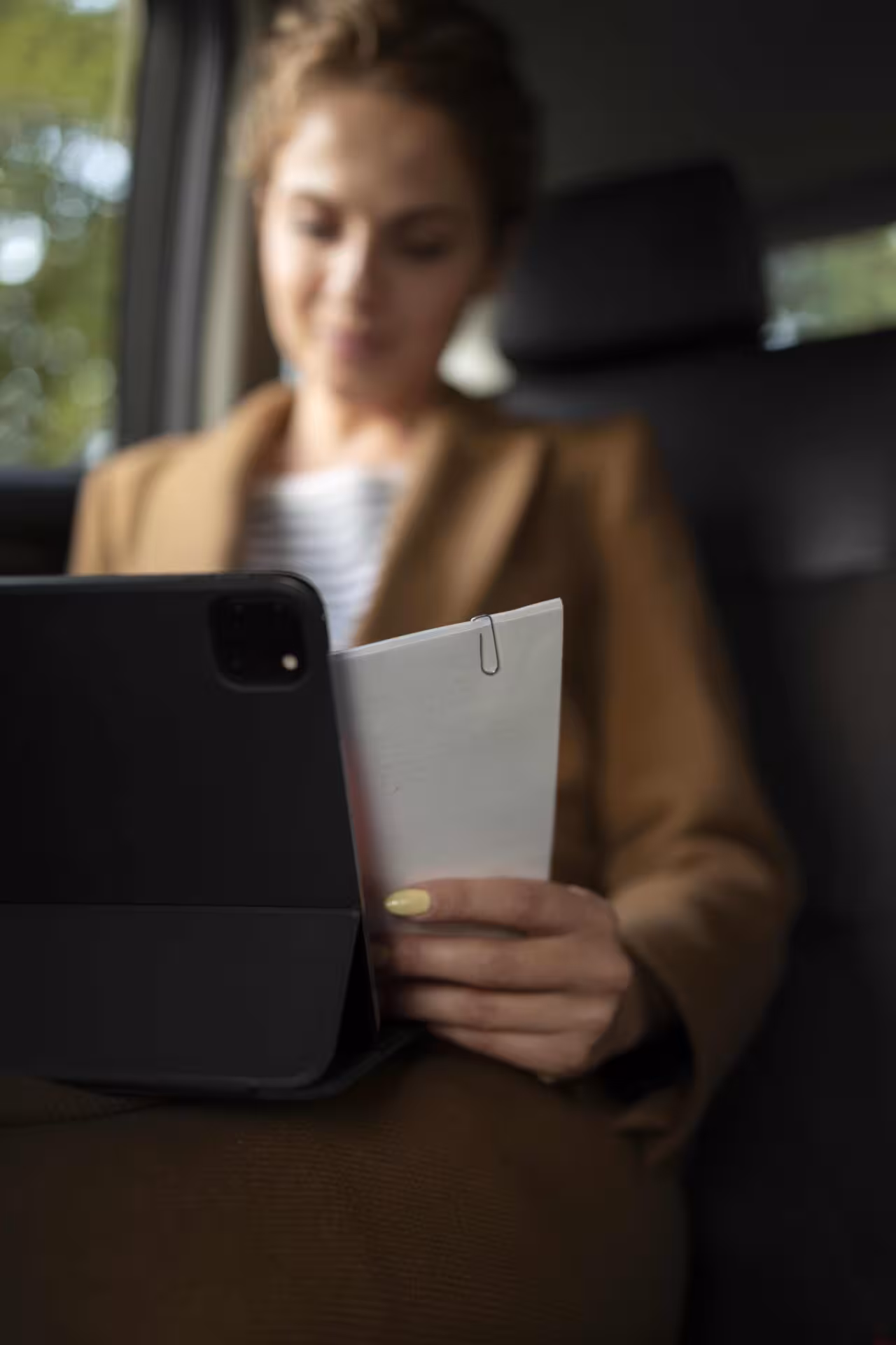 Donna che utilizza un tablet durante un viaggio in auto di lusso NCC